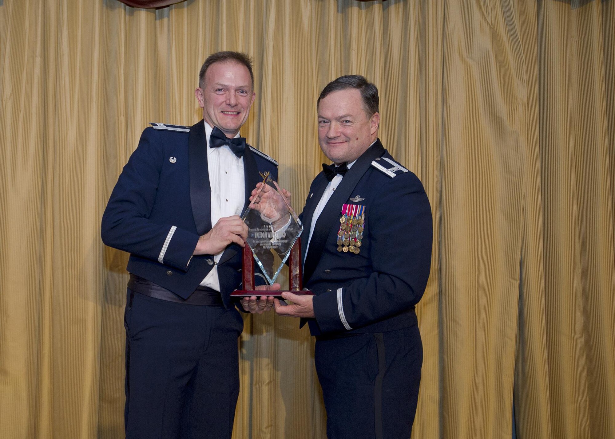 Col. Robert Dunham, 514th Operations Group commander, receives the Freedom Wing award, group level, from Col. David Pavey, 514th Air Mobility Wing commander, during the wing's annual awards banquet Feb. 11.