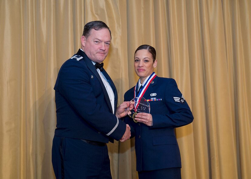 Senior Airman Yvette Guillen, 514th Operations Support Squadron, receives the Airman of the year award from Col. David Pavey, 514th Air Mobility Wing commander, during the wing's annual awards banquet Feb. 11.