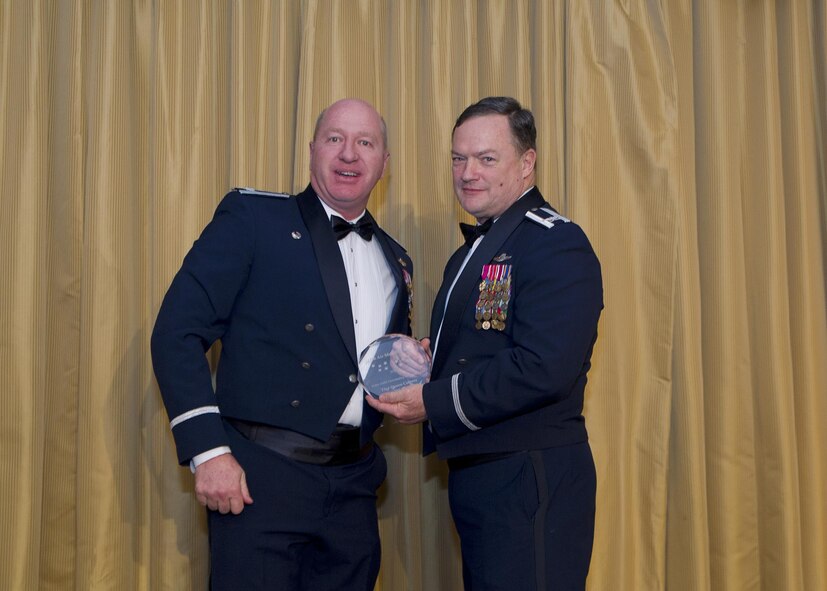 Lt. Col. Samuel Irving, 732nd Airlift Squadron, stands in for Tech. Sgt. Steven Cabrera to receive the Non-Commissioned Officer of the Year award from Col. David Pavey, 514th Air Mobility Wing commander, during the wing's annual awards banquet Feb. 11.