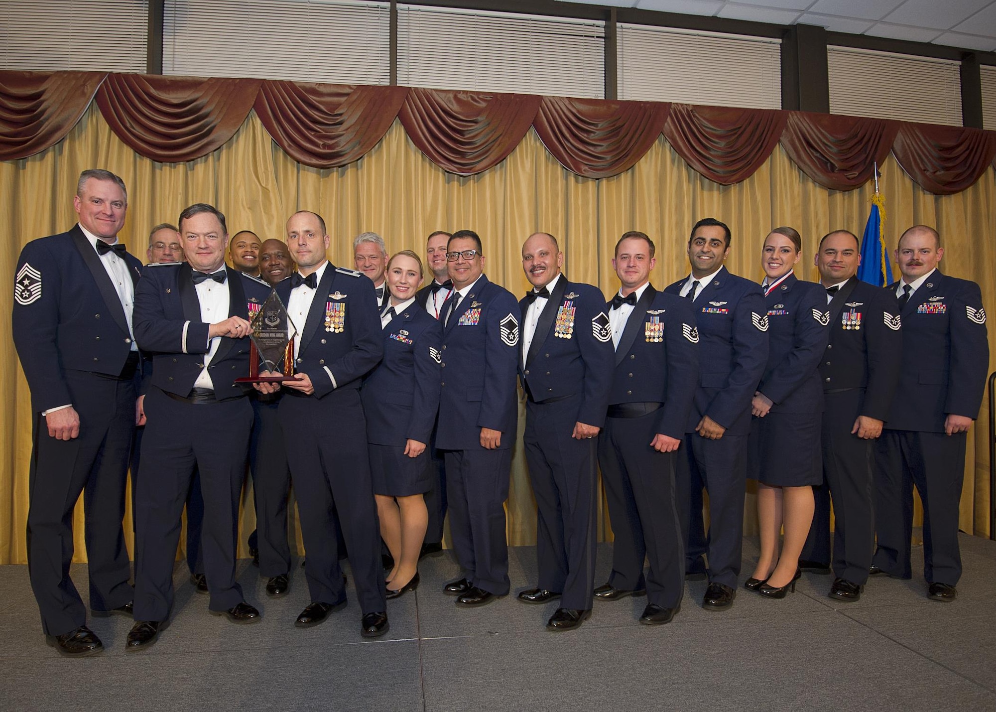 Members of the 514th Operations Support Squadron receive the Freedom Wing award, squadron level, from Col. David Pavey, 514th Air Mobility Wing commander, during the wing's annual awards banquet Feb. 11.