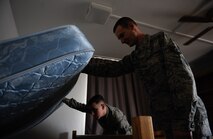 Airman 1st Class Blake Gunderson(left), 24th Intelligence Squadron technical reporter, and Tech. Sgt. Gentry Koepp(right), 86th Civil Engineering Squadron unaccompanied housing NCO in charge, lift a mattress during a dorm inspection on Ramstein Air Base, Germany, Feb. 7, 2017. The Dorm Reception Center thoroughly inspects the rooms for cleanliness before Airmen vacate. (U.S. Air Force photo by Airman 1st Class Savannah L. Waters)