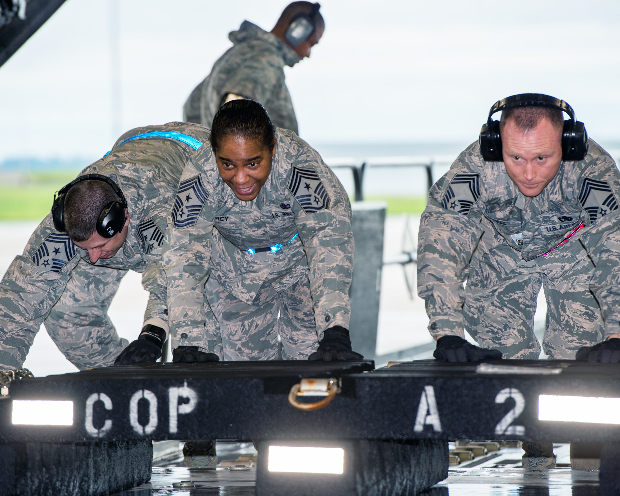 U.S. Air Force Chief Master Sgt. Shelina Frey, center, Air Mobility Command command chief, Scott Air Force Base Ill., pushes a pallet inside a C-17 Globemaster III during her tour of the 60th Aerial Port Squadron at Travis Air Force Base, Calif., Feb. 8, 2017. Frey is on a five-day tour to Travis visiting with Airmen, observing operations and recognizing the newest chief master sergeants. (U.S. Air Force photo/Louis Briscese)