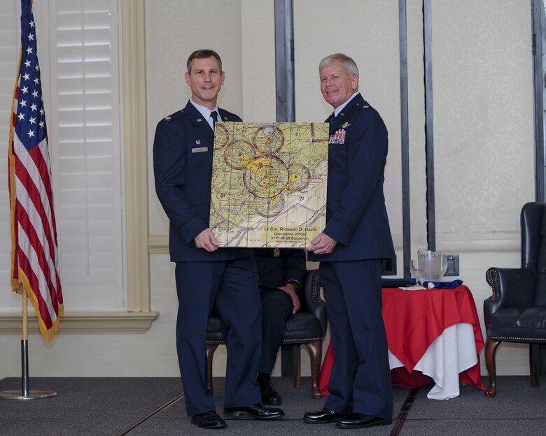 (From left) 317th Airlift Squadron Commander, Lt. Col. Stan Davis, presents retiring, Lt.. Col. Rick Davis, 317th AS, with a gift of a Charleston air space map during his retirement ceremony at Joint Base Charleston, S.C Feb. 12. (U.S. Air Force photo by Senior Airman Tom Brading)