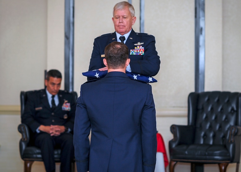 Lt. Col. Rick Davis, 317 Airlift Squadron, is presented a U.S. Flag during his retirement ceremony at Joint Base Charleston, S.C Feb. 12. (U.S. Air Force photo by Senior Airman Tom Brading)