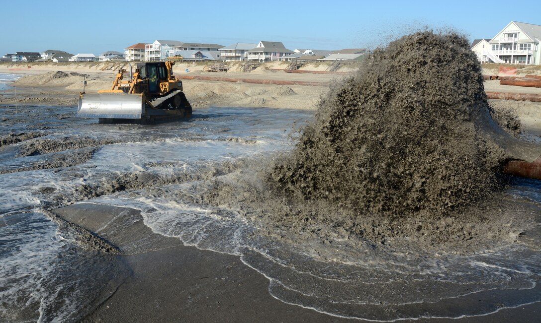 A heavy equipment operator prepares to move dredged material during a Storm Damage Reduction Project at Ocean Isle, North Carolina.
