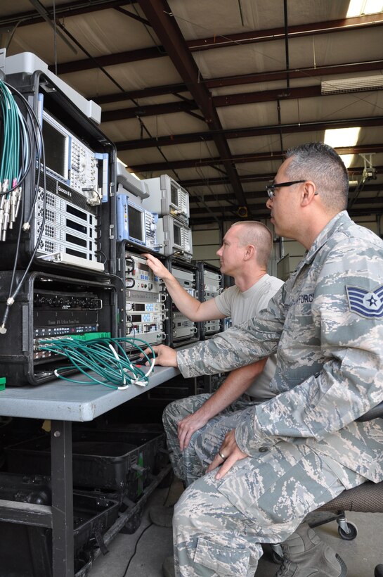 (Front to rear) Tech. Sgt. Matthew Guterriz, threat analyst, and Tech. Sgt. Kevin Broyles, radio frequency transmissions technician, set up satellite communication equipment for a training exercise. SATCOM is used to jam communications, replicating a contested environment for operators. SATCOM can be conducted from Schriever AFB for exercises happening at Nellis AFB. (U.S. Air Force photo/Maj. Jessica D'Ambrosio)  