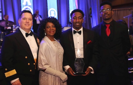 WASHINGTON (Feb. 11, 2017) - Dwayne Nelson, Naval Surface Warfare Center (NSWC) Dahlgren Division engineer, holds his Black Engineer of the Year (BEYA) Community Service Award at the 31st annual BEYA gala. Standing left to right are NSWC Commander RDML Tom Druggan; Dwayne's mother, Linda; Dwayne; and his brother, Rudy. "I would like to thank Rear Adm. Tom Druggan, the Rappahannock Big Brothers Big Sisters and the Naval Surface Warfare Center Dahlgren Division for supporting me throughout my career," said Nelson. "The endless encouragement and invaluable learning have changed me forever." (U.S. Navy photo/Released)