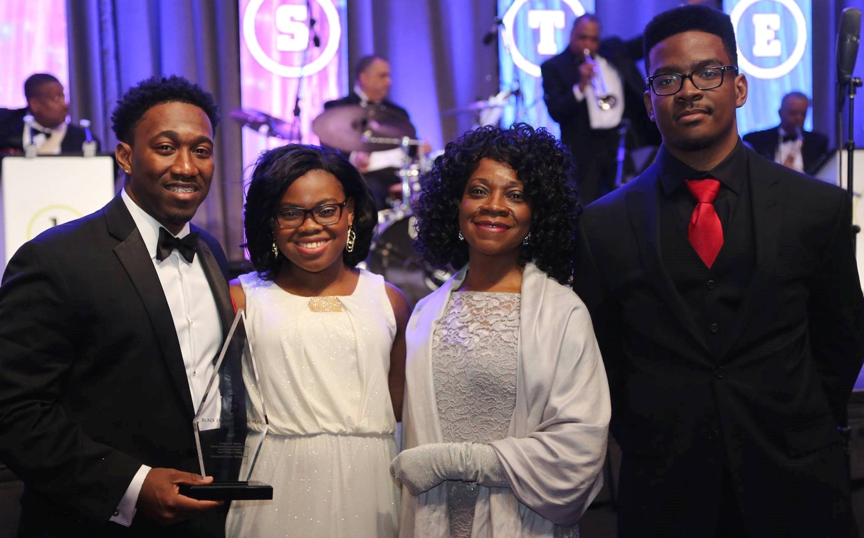 WASHINGTON (Feb. 11, 2017) - Dwayne Nelson, Naval Surface Warfare Center Dahlgren Division engineer, holds his Black Engineer of the Year (BEYA) Award after being honored for his community service accomplishments at the 31st annual BEYA gala. Standing left to right are Dwayne; his sister, Olivia; mother, Linda; and brother, Rudy. "To my family, friends, Alpha Phi Alpha fraternity brothers, and co-workers, a simple thank you is definitely not enough to tell you how much I wholeheartedly appreciate everything you’ve done for me," said Nelson. "I never would have made it here without you. Your support has been amazing!" (U.S. Navy photo by Rear. Adm. Tom Druggan/Released)