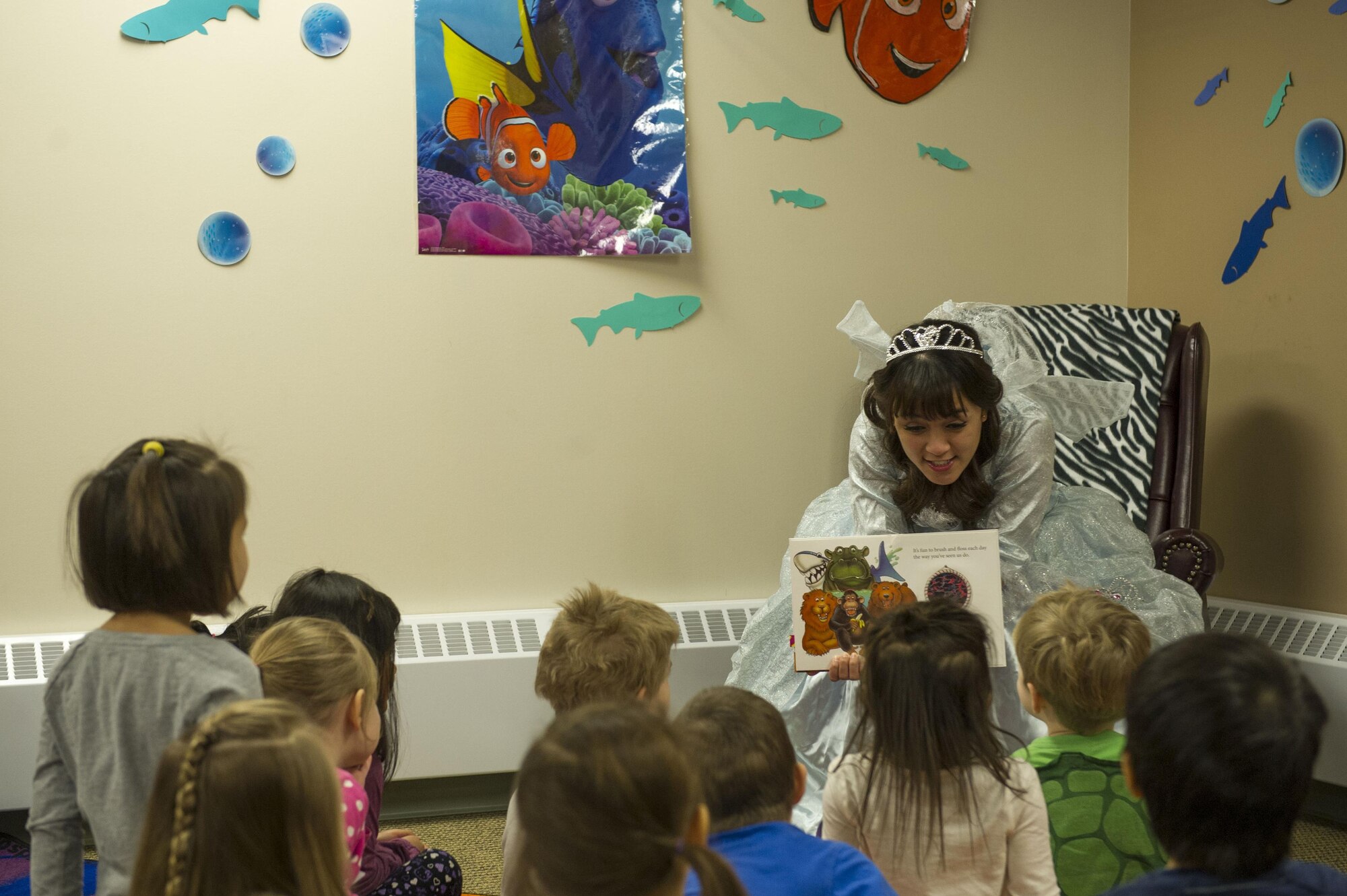 U.S. Air Force Senior Airman Shiermaine Francisco, a 354th Medical Operations Squadron dental assistant, reads a book to children during story time Feb. 2, 2016, at Eielson Air Force Base, Alaska. Members of the Eielson Dental Clinic visited children to raise awareness for National Children’s Dental Health month. (U.S. Air Force photo by Airman Isaac Johnson)