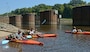 Three paddlers launch their vessels at Lock and Dam 3 on the Cape Fear River.  