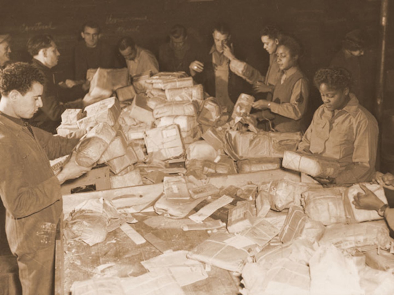 French civilians and soldiers from the 6888th Central Postal Directory Battalion sort mail in France during the spring of 1945.