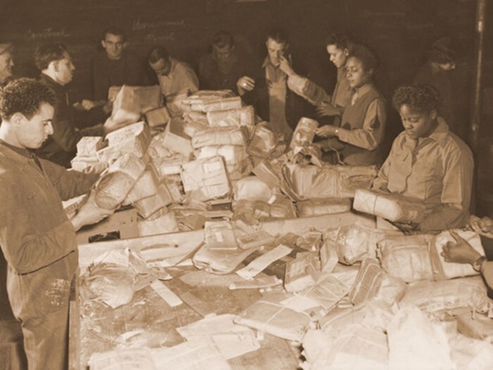French civilians and soldiers from the 6888th Central Postal Directory Battalion sort mail in France during the spring of 1945.