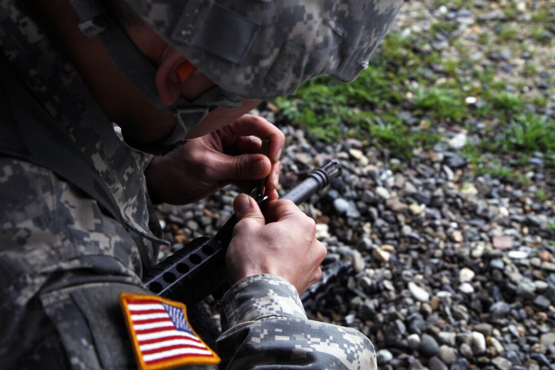 During the zero portion of qualifications Best Warrior candidate Sgt. Quilaton changes his front sight post, Fort Hunter Liggett, Calif. on February 8, 2017. Quilaton changed his front sight post to raise the point of impact on the target. 