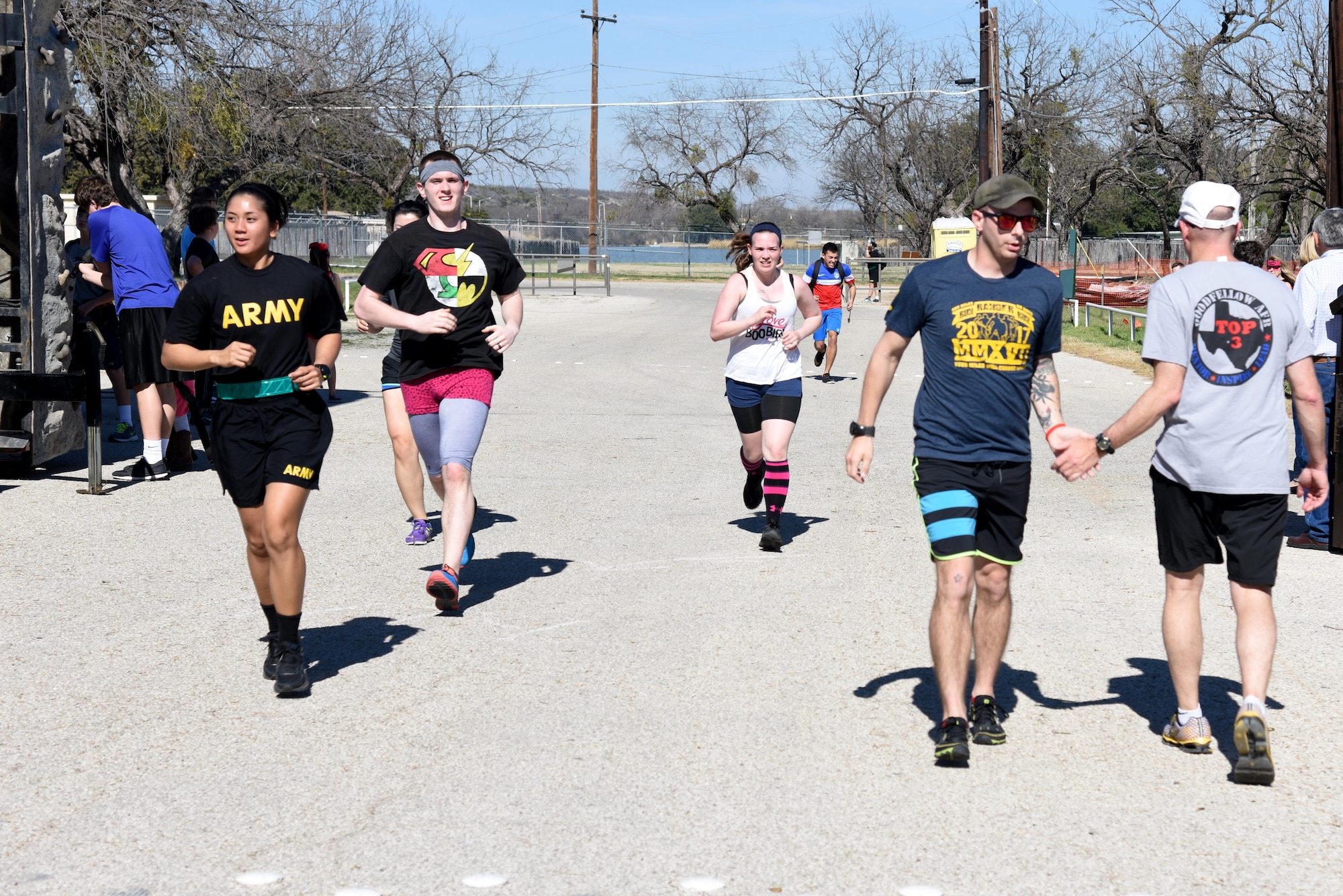 U.S. Air Force Col. Michael Downs, 17th Training Wing Commander, congratulates runners as they finish the Polar Bear Party 5K at the Goodfellow Air Force Base Recreation Camp in San Angelo, Texas, Feb. 11, 2017. After the run, participants also got the chance to take a plunge into Lake Nasworthy. (U.S. Air Force photo by Staff Sgt. Joshua Edwards/Released)