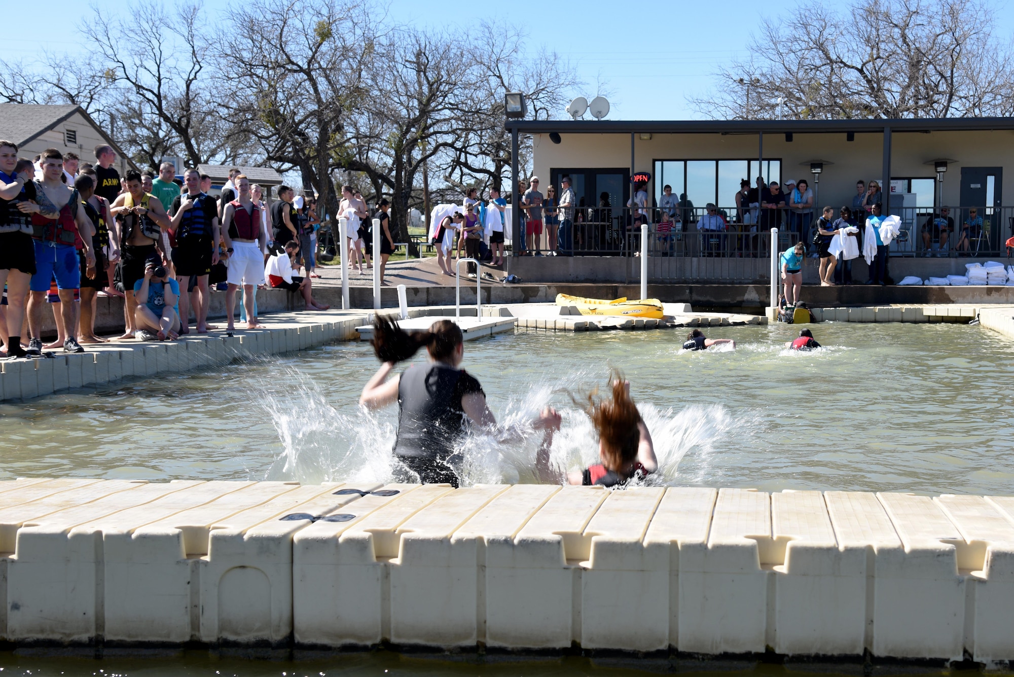 Participants jump into Lake Nasworthy during the Polar Bear Party at the Goodfellow Air Force Base Recreation Camp in San Angelo, Texas, Feb. 11, 2017. This is the 16th year that the 17th Force Support Squadron has hosted the Polar Bear Party. (U.S. Air Force photo by Staff Sgt. Joshua Edwards/Released)