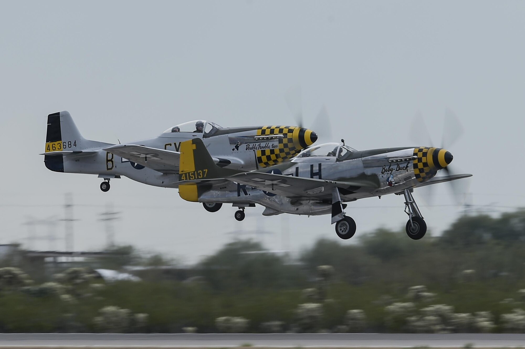 Two P-51 Mustangs take off during the 2017 Heritage Flight Training and Certification Course at Davis-Monthan Air Force Base, Ariz., Feb. 12, 2017. During the course, aircrews practice ground and flight training to enable civilian pilots of historic military aircraft and U.S. Air Force pilots of current fighter aircraft to fly safely in formations together. (U.S. Air Force photo by Senior Airman Chris Drzazgowski)