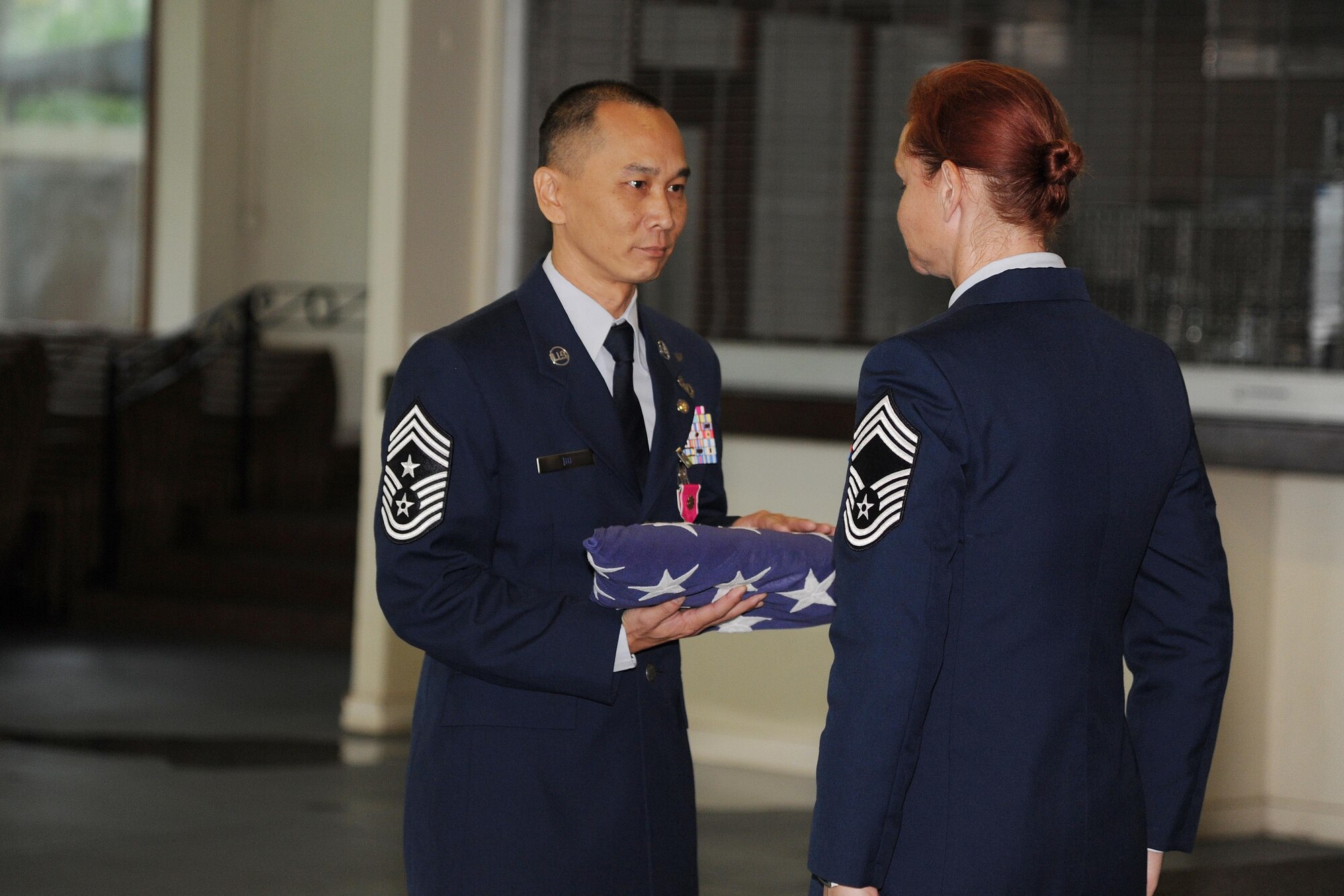 U.S. Air Force Command Chief Master Sgt. Michael Du, of Walnut, Calif., accepts an American Flag from Chief Master Sgt. Tara Corse during his retirement ceremony at the Historic Hickam Officers Club, Joint Base Pearl Harbor-Hickam, Hawaii, Feb. 11, 2017. Du culminated his 25 year career as the senior enlisted leader for the 624th Regional Support Group. Located on Oahu and Guam, and a component of the Air Force Reserve, the 624th Regional Support Group's mission is to deliver mission essential capability through combat readiness, quality management and peacetime deployments in the Pacific area of responsibility. (U.S. Air Force photo by Master Sgt. Theanne Herrmann)