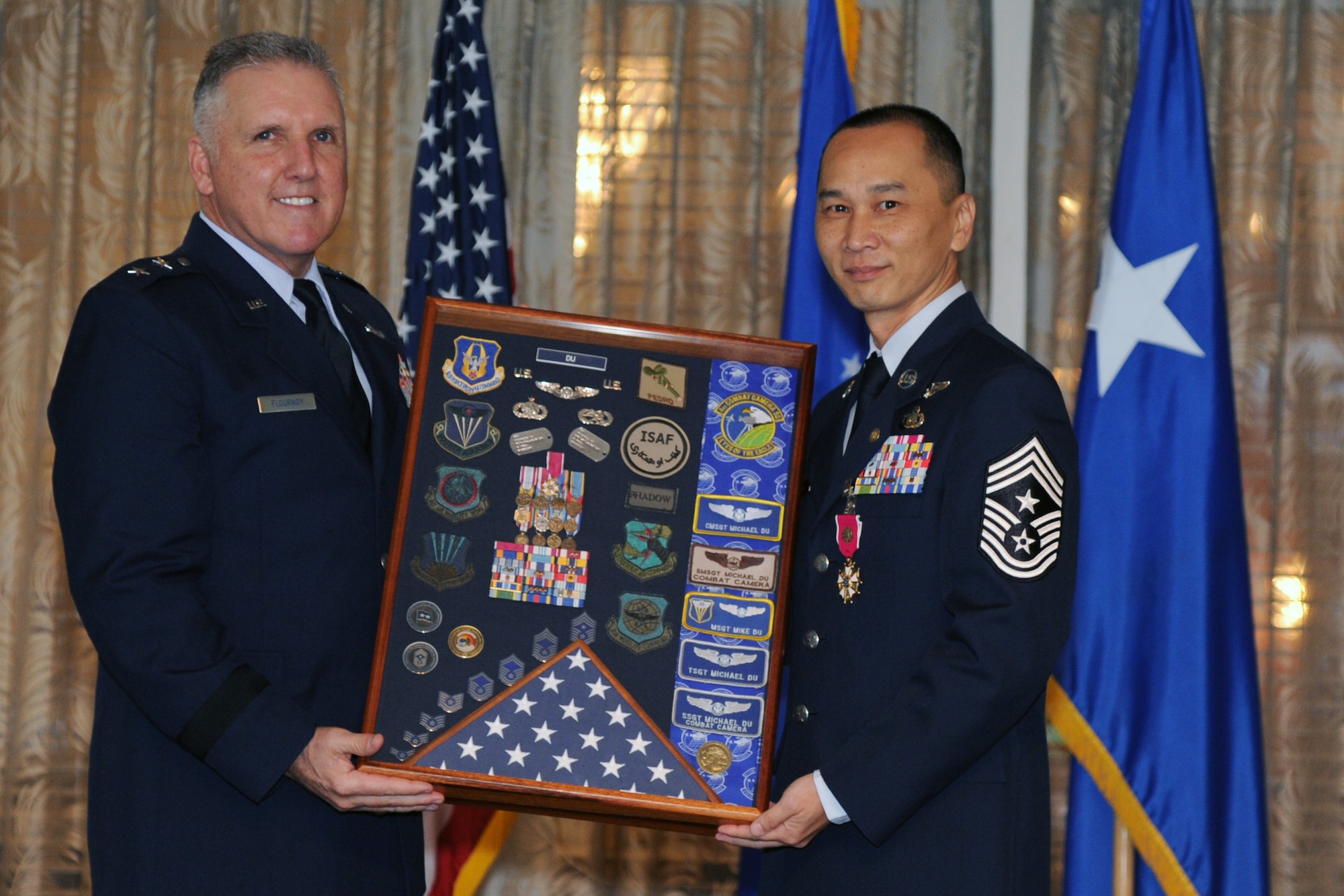 U.S. Air Force Maj. Gen. John C. Flournoy presents Command Chief Master Sgt. Michael Du, of Walnut, Calif., with a shadow box commemorating more than 25 years of military service during his retirement ceremony at the Historic Hickam Officers Club, Joint Base Pearl Harbor-Hickam, Hawaii, Feb. 11, 2017. Du spent more than two years as the senior enlisted leader for the 624th Regional Support Group. Located on Oahu and Guam, and a component of the Air Force Reserve, the 624th Regional Support Group's mission is to deliver mission essential capability through combat readiness, quality management and peacetime deployments in the Pacific area of responsibility. (U.S. Air Force photo by Master Sgt. Theanne Herrmann)