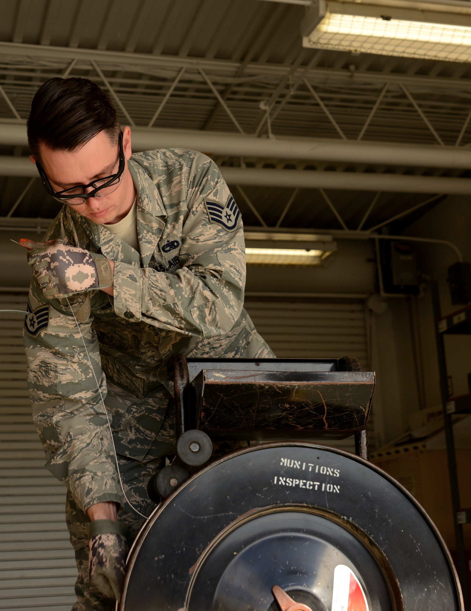 U.S. Air Force Staff Sgt. Ralph Simons, 20th Equipment Maintenance Squadron munitions inspector, measures metal banding at Shaw Air Force Base, S.C., Feb. 6, 2017. The metal banding is used to secure crates of packed munitions following inspection and before storage. (U.S. Air Force photo by Airman 1st Class Kathryn R.C. Reaves)