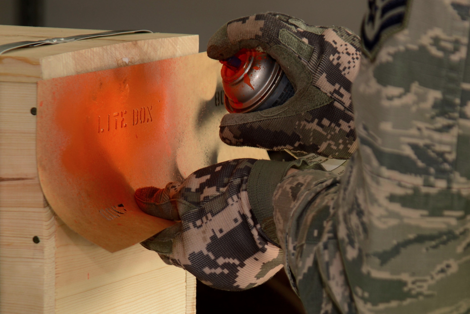 U.S. Air Force Staff Sgt. Ralph Simons, 20th Equipment Maintenance Squadron munitions inspector, uses a template to spray-paint words onto a crate at Shaw Air Force Base, S.C., Feb. 6, 2017. The words, “LITE BOX,” indicate the crate has less than a full set of munitions. (U.S. Air Force photo by Airman 1st Class Kathryn R.C. Reaves)