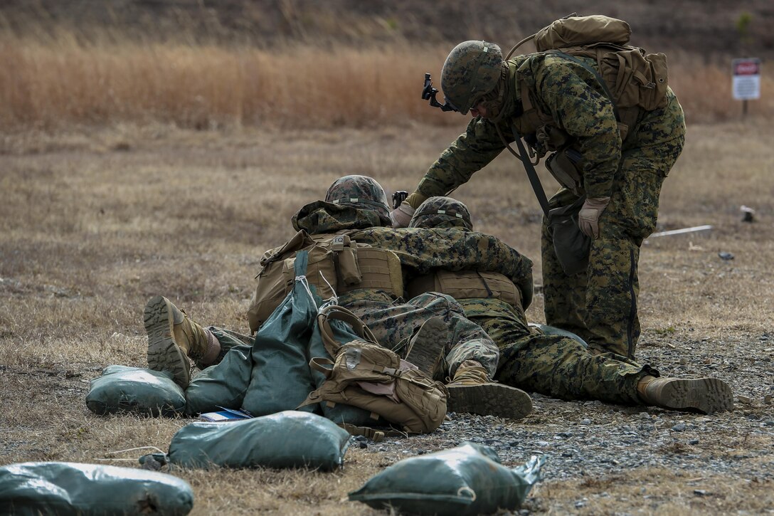 A Position Safety Officer with Bravo Company, Marine Barracks Washington D.C., coaches Marines as they fire rounds from the M-249 light machine-gun (SAW) on Marine Corps Base Quantico, Va., Feb. 9, 2017. Marines with Co. B executed training evolutions throughout the week to hone their skills on machineguns and high-explosive weapons organic to an infantry squad. (Official Marine Corps photo by Lance Cpl. Damon A. Mclean/Released)
