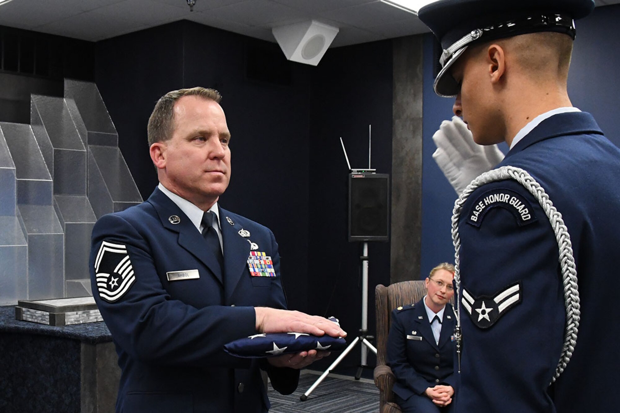 U.S. Air Force Senior Master Sgt. Robert Ahbol, the 307th Force Support Squadron communications flight superintendent, accepts a U.S. flag during his retirement ceremony at Barksdale Air Force Base, La., Feb. 11, 2017.   Ahbol was responsible for setting up the first ever computer network in the 917th Wing before it deactivated.  Once the 307th Bomb Wing was reactivated in place of the 917th Wing, Ahbol continued to monitor and expand the network, standing up the first Reserve Mission in the Air Force Network Operations Center.  (U.S. Air Force photo by Staff Sgt. Callie Ware/Released)