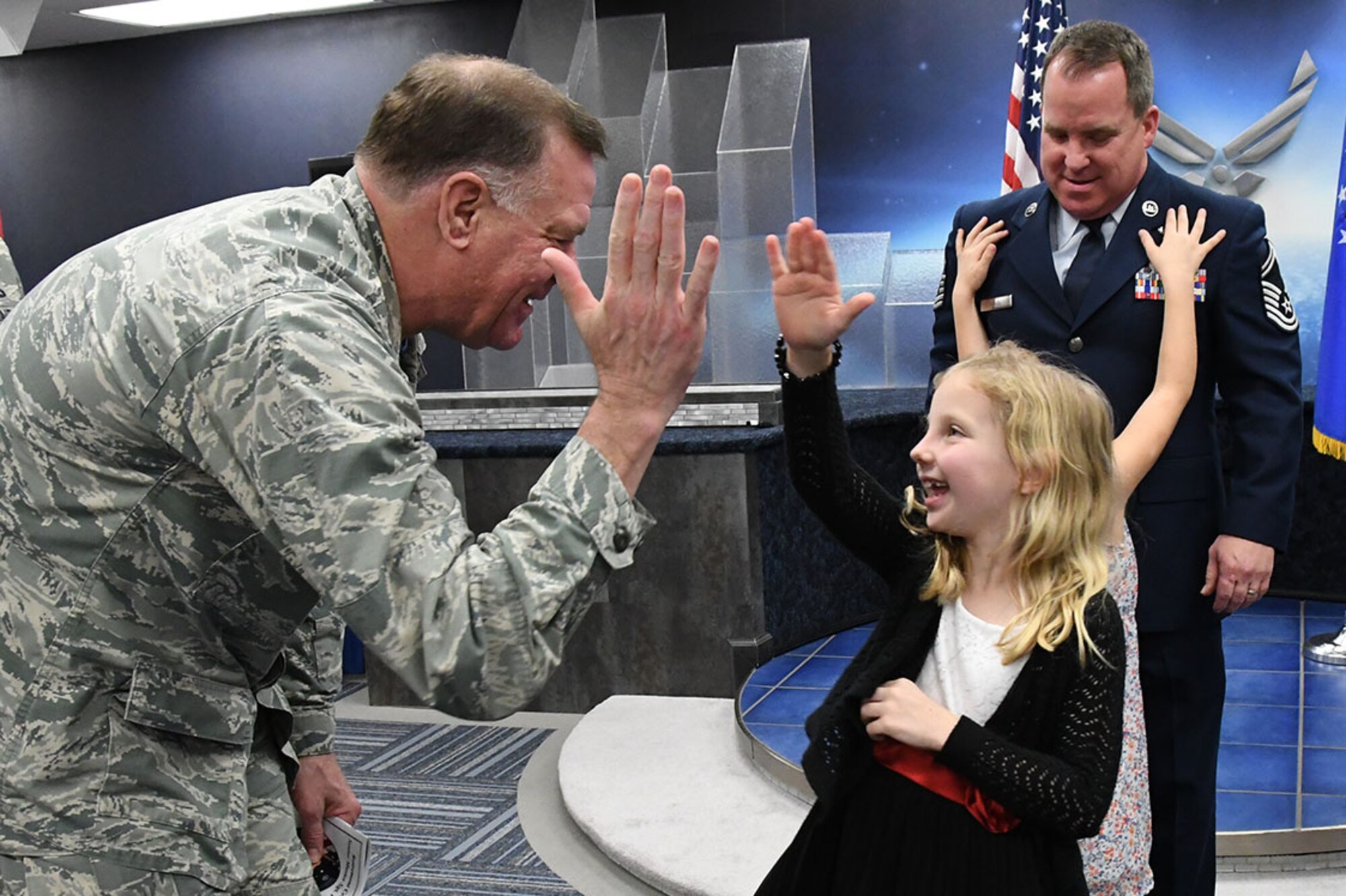 Lieutenant Colonel Leo J. Kamphaus, Jr., 307th Maintenance Group commander, high-fives Olivia Ahbol after the retirement ceremony for her father, retired Senior Master Sergeant Rob Ahbol, at Barksdale Air Force Base, La., Feb. 11, 2017.  Ahbol served as the communications flight superintendent for both the 917th Wing and the 307th Bomb Wing.  While still an Aerospace Ground Equipment mechanic with the 917th Wing, he created the Smart Pay Tracking System.  In doing so, he helped the wing win its second Chief of Staff Team Excellence Award.  Ahbol is retiring with than 31 years of service.  (U.S. Air Force photo by Staff Sgt. Callie Ware/Released)