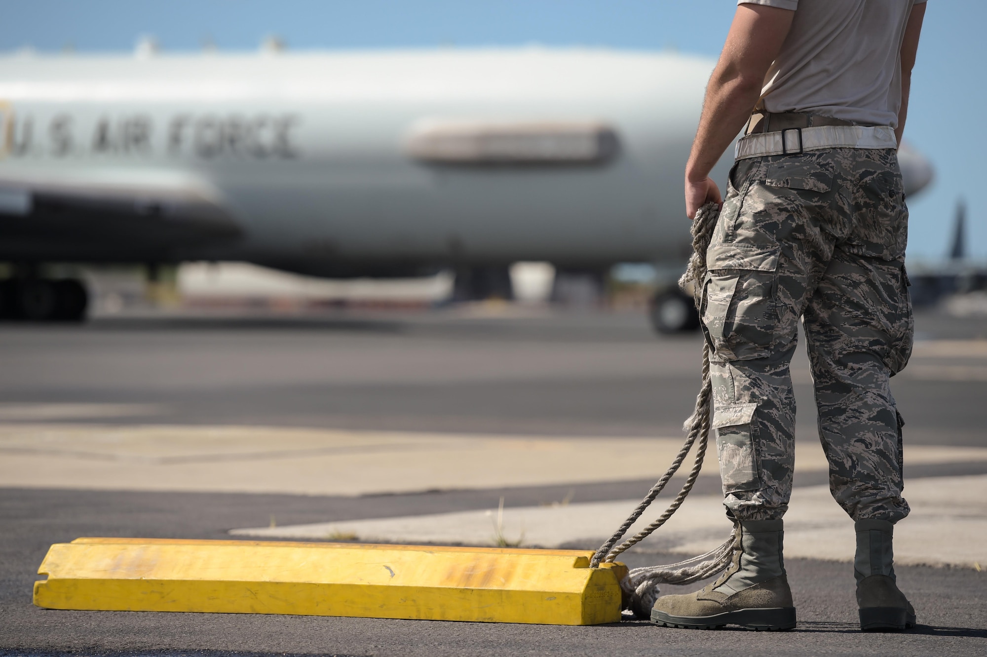 An Airman assigned to the 513th Aircraft Maintenance Squadron waits for an E-3 Sentry Airborne Warning and Control System aircraft to taxi into place Jan. 25 after returning from a mission at Joint Base Pearl Harbor-Hickam, Hawaii. Reservists from the 513th Air Control Group deployed to the Hawaiian Islands to provide command and control for Sentry Aloha 17-01, a primarily Reserve and Air National Guard exercise that involves more than 40 aircraft and 1,000 personnel. (U.S. Air Force photo by 2nd Lt. Caleb Wanzer)