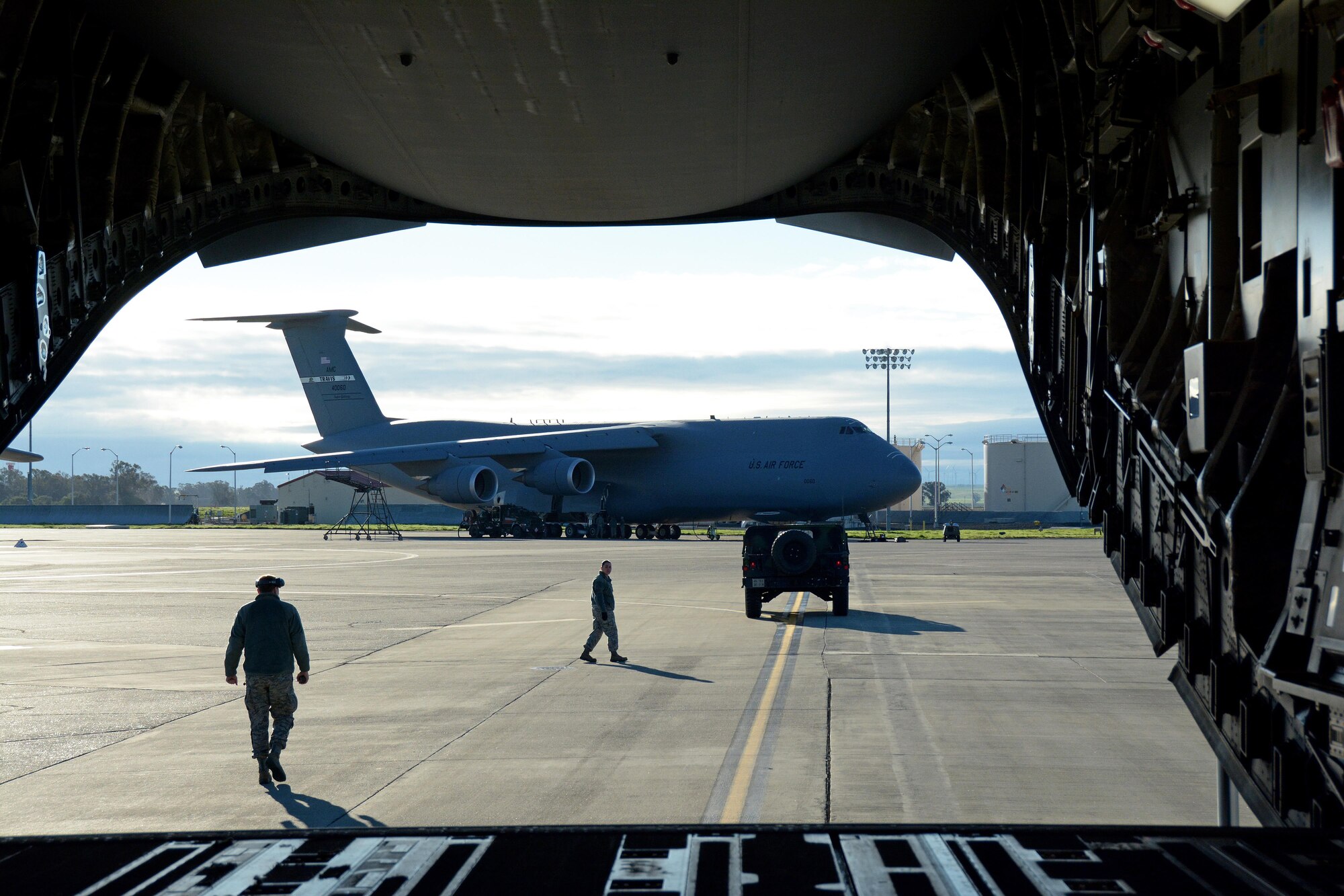 Citizen Airmen from the 55th Areoport Squadron guide a Humvee into place before it is backed into a C-17 Globemaster III prior to its take off from Travis Air Force Base, Calif., for Patriot Wyvern on Feb. 11, 2017. Patriot Wyvern is a hands-on, bi-annual event conducted by the 349th Air Mobility Wing designed to hone combat skills and improve organizational interoperability. (U.S. Air Force photo/Staff Sgt. Daniel Phelps)