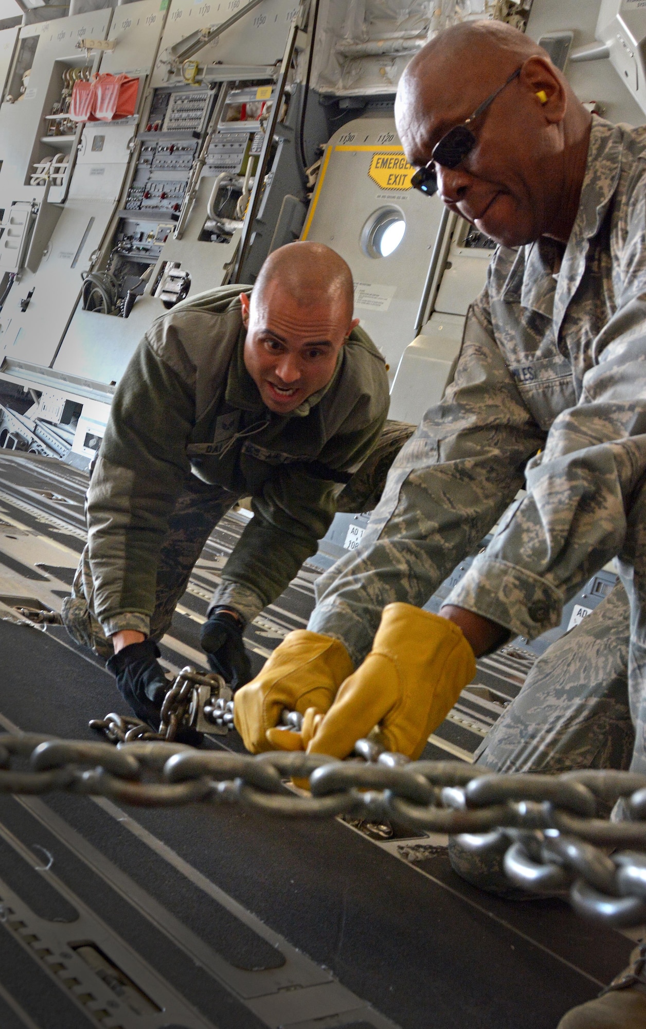 Senior Airman Frank Dalao and Master Sgt. Vantory Miles, 55th Aeroport Squadron air transportation specialists, chain down a Humvee in a C-17 Globemaster III prior to its take off from Travis Air Force Base, Calif., for Patriot Wyvern on Feb. 11, 2017. Patriot Wyvern is a hands-on, bi-annual event conducted by the 349th Air Mobility Wing designed to hone combat skills and improve organizational interoperability. (U.S. Air Force photo/Staff Sgt. Daniel Phelps)