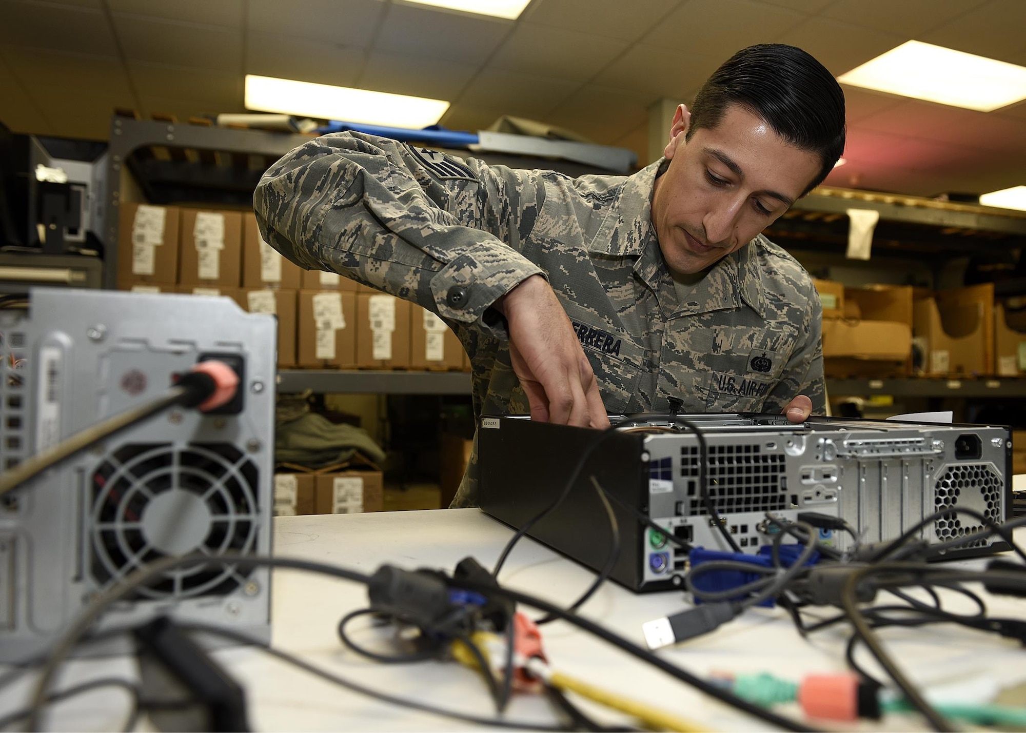 PETERSON AIR FORCE BASE, Colo. – Staff Sgt. Derrek DeHerrera, 561st Network Operations Squadron vulnerability remediation supervisor, works on a central processing unit while visiting his old office, the 21st Communications Squadron, on Peterson Air Force Base, Colo., Jan. 27, 2017. DeHerrera went to Korea as client systems, retrained into cyber systems operations, and was stationed back at Peterson. (U.S. Air Force photo by Senior Airman Rose Gudex)