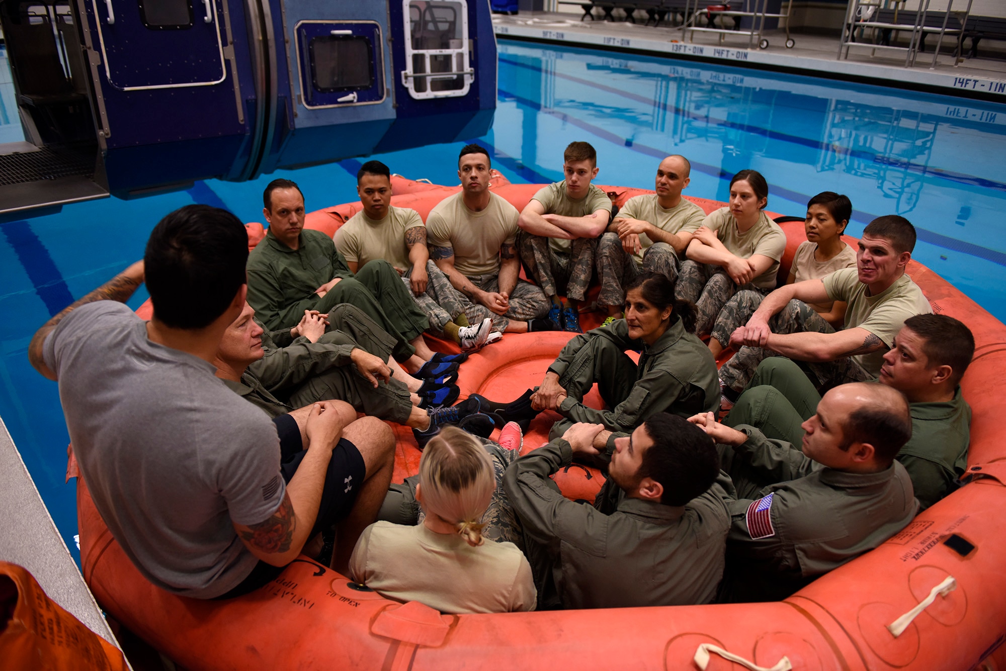 Four NASA astronauts sit in with a class of Survival School students being briefed on life raft procedures Feb. 10, 2017, at Fairchild Air Force Base, Wash. Water survival training is hosted by the base Fitness Center pool facilities. (U.S. Air Force photo/ Airman 1st Class Ryan Lackey)