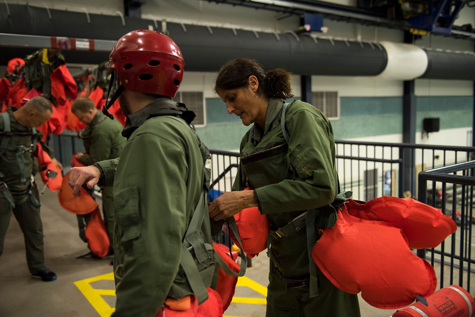 Sunita Williams, NASA astronaut, helps a fellow crew member suit up in preparation for water survival training Feb. 10, 2017, at Fairchild Air Force Base, Wash. The Survival School is the only military unit solely dedicated to survival and rescue training. (U.S. Air Force photo/ Airman 1st Class Ryan Lackey)