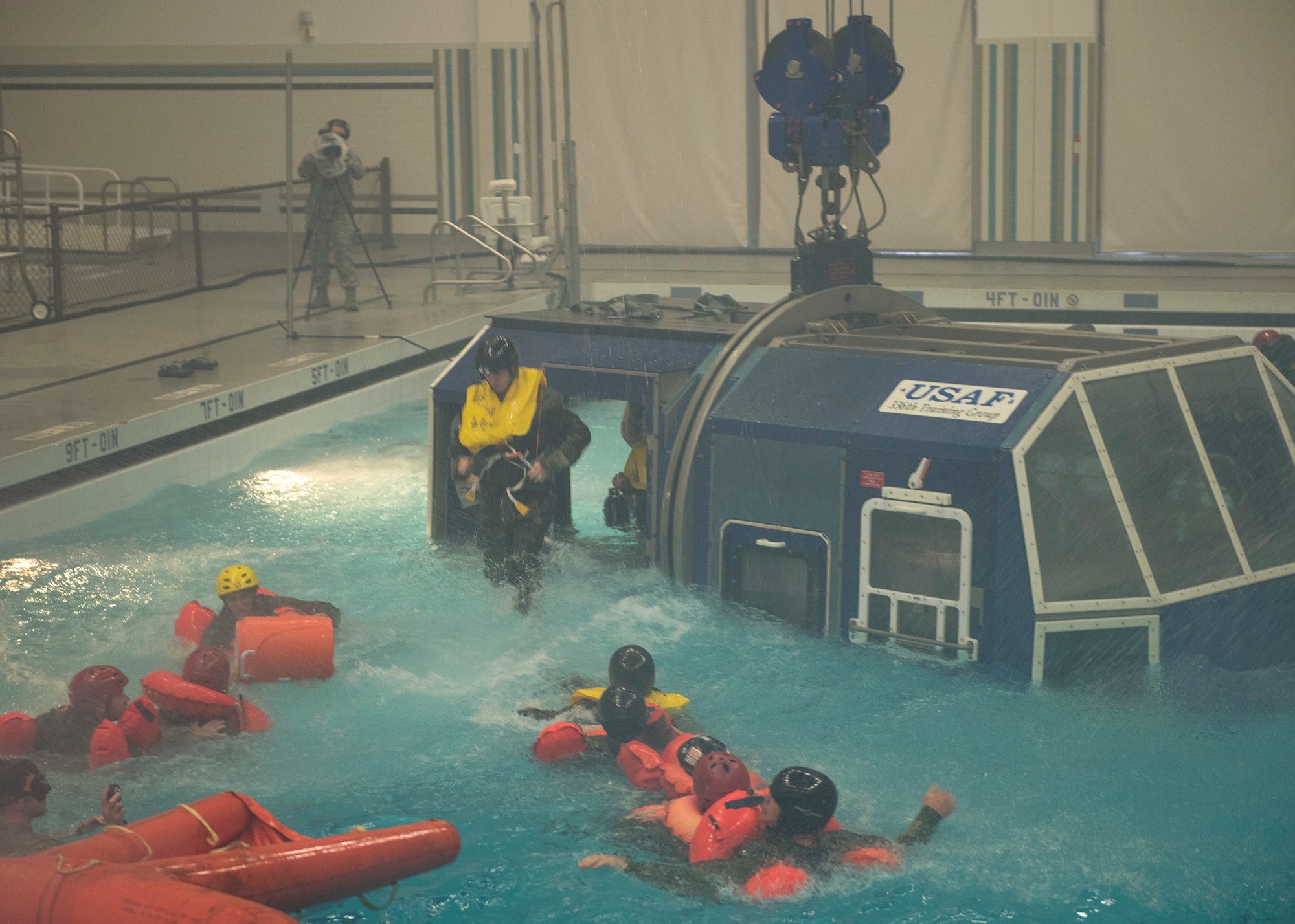 NASA astronauts bail out of a crash simulator during water survival training Feb. 10, 2017, at Fairchild Air Force Base, Wash. The Survival School uses a crane apparatus to simulate an aircraft and is equipped with water, sound and light effects. (U.S. Air Force photo/ Airman 1st Class Ryan Lackey)