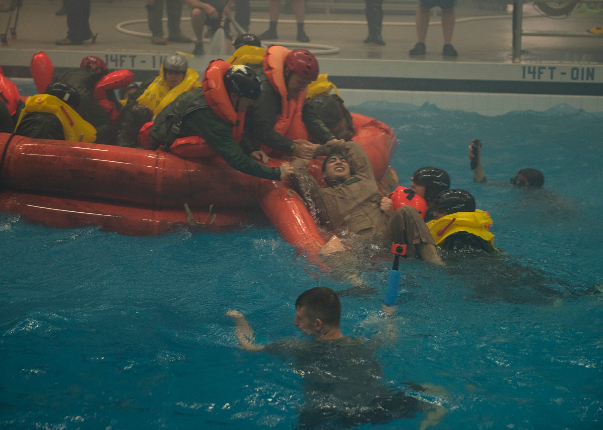 NASA astronauts and Survival School students help pull survivors into a life raft during a simulation Feb. 10, 2017, at Fairchild Air Force Base, Wash. Water survival instructors are hands on teachers, jumping into the action alongside their students. (U.S. Air Force photo/ Airman 1st Class Ryan Lackey)