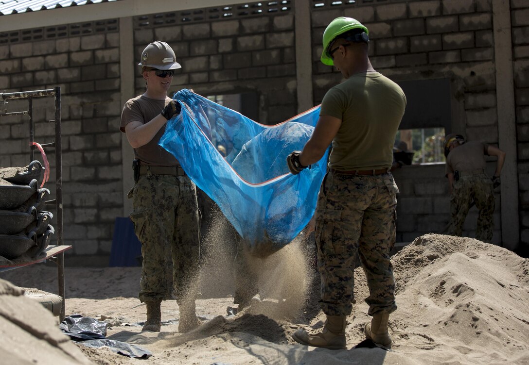 U.S. Marine Corps Cpl. Mario Rojas, with Marine Wing Support Squadron 172, and U.S. Navy Constructionman Elijah Farladansky-Doyle, a steel worker with Naval Mobile Construction Battalion 5, assist in the construction of a classroom at Ban Kok Kee San Toor, Khon Kaen Province, Thailand during the 36th iteration of exercise Cobra Gold, on Feb. 11, 2017.  Similar to last year, Cobra Gold 17 emphasizes coordination on civic action, such as humanitarian assistance and disaster relief, seeking to expand regional cooperation and collaboration in these vital areas.  (U.S. Marine Corps photo by Staff Sgt. Nathan O. Sotelo)