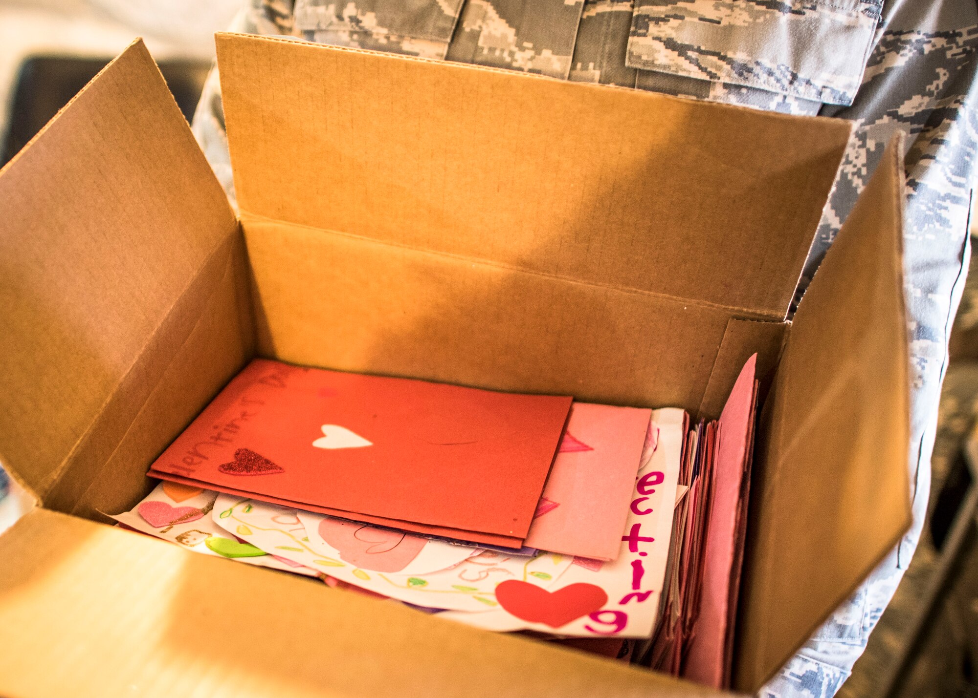 An Airman holds a box of Valentine’s Day cards, Feb. 14, 2017, in Southwest Asia. Students from Cape Cod, Massachusetts handcrafted cards for service members serving overseas. (U.S. Air Force photo by Staff Sgt. Eboni Reams)