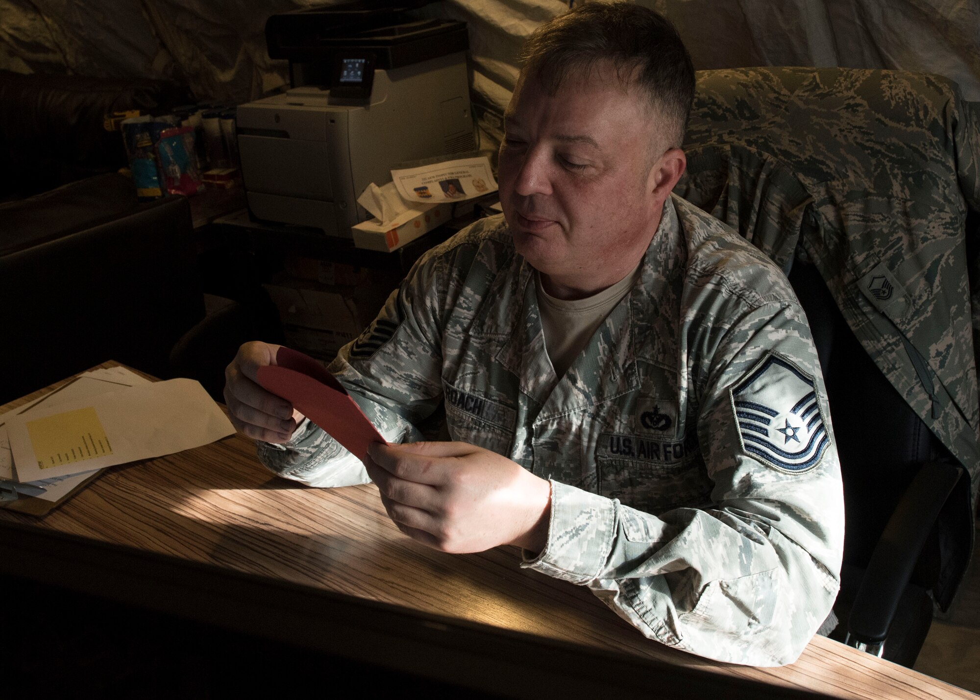 Master Sgt. Paul Roach, 332nd Expeditionary Civil Engineer Squadron assistant chief of training, reads a Valentine’s Day card, Feb. 14, 2017, in Southwest Asia. Students from Cape Cod, Massachusetts handcrafted cards for service members serving overseas. (U.S. Air Force photo by Staff Sgt. Eboni Reams)