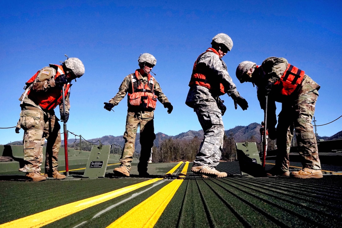 Army National Guard soldiers work to secure a ramp on a temporary float bridge at Whiskeytown Lake, near Redding, Calif., Feb. 11, 2017. Army National Guard photo by Spc. Amy E. Carle