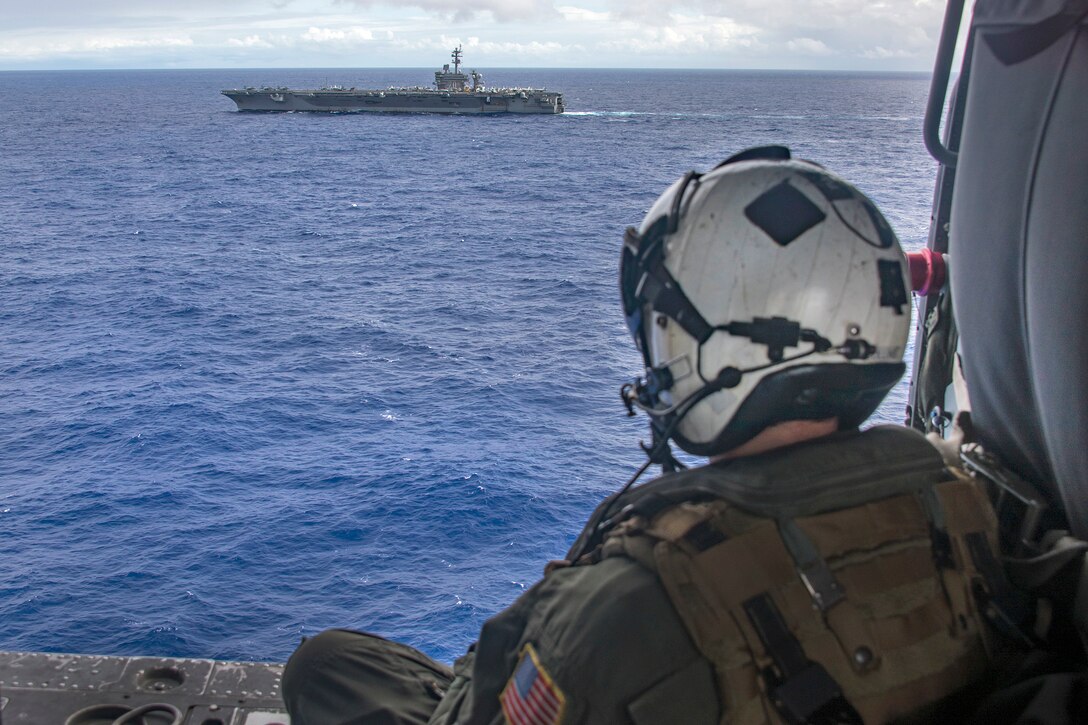 Navy Petty Officer 1st Class Sean Collins observes the aircraft carrier USS Carl Vinson as it transits in the Pacific Ocean, Feb. 4, 2017. Collins is an aircrewman. The Carl Vinson Carrier Strike Group is on a regularly scheduled Western Pacific deployment as part of the U.S. Pacific Fleet-led initiative to extend the command and control functions of U.S. 3rd Fleet. Navy photo by Petty Officer 2nd Class Sean M. Castellano