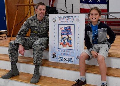 Lt. Col. Nathan Schwamburger, 628th Medical Group Dental Clinic chief of dental services, left, sits with Francisco Bartolome, Marrington Elementary School student body president, during a National Children’s Dental Health Month outreach event at Marrington Elementary School, Feb. 10, 2017. Establishing a good dental routine and going to the dentist regularly at an early age can help children develop life-long habits for healthy teeth and gums. The dental clinic will reach out to the Child Development Center, youth center and other schools throughout the month of February to educate children on dental health.