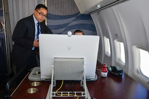 Air Force Staff Sgt. John Operana, 1st Airlift Squadron communication systems operator, looks on as Marine Staff Sgt. Corey Riley, U.S. Central Command advanced communicator, operates a video conferencing system during a flight on board a C-40B aircraft to Naval Air Station Souda Bay, Greece, Feb. 4, 2017. Secure and non-secure Video Teleconference and other communications are vital to all 89th Airlift Wing passenger missions, as directed by the White House or Air Force Vice Chief of Staff for Special Air Missions. (U.S. Air Force photo by Senior Master Sgt. Kevin Wallace)
