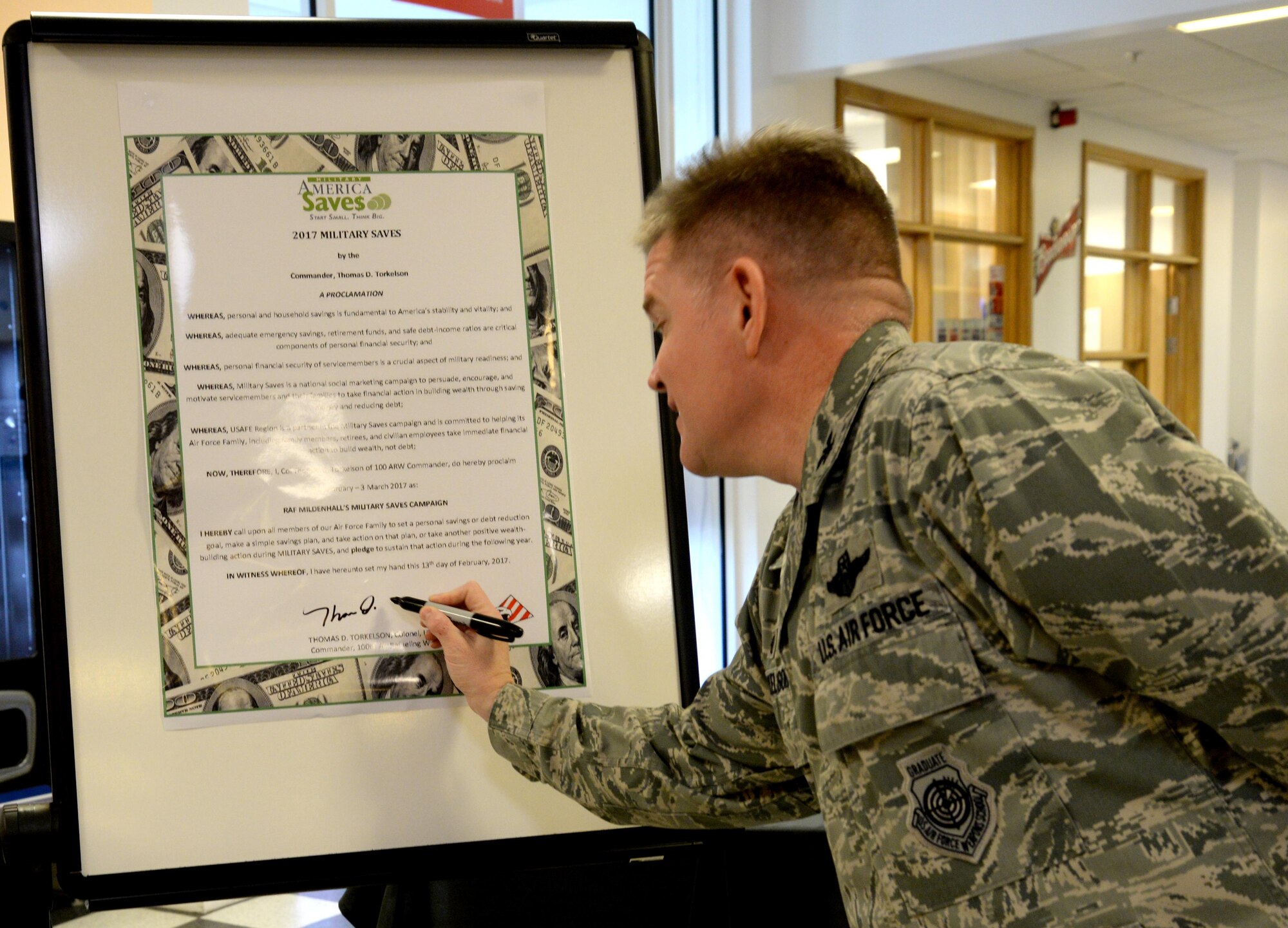 U.S. Air Force Col. Thomas Torkelson, 100th Air Refueling Wing commander, signs the 2017 Military Saves proclamation, Feb. 13, 2017, at the bowling center on RAF Mildenhall, England. Following the signing, Team Mildenhall personnel participated in a free scotch doubles bowling tournament hosted by the Airman and Family Readiness Center. Financial education classes are scheduled at both RAF Mildenhall and RAF Lakenheath Feb. 14 through March 3. (U.S. Air Force photo by Senior Airman Justine Rho)