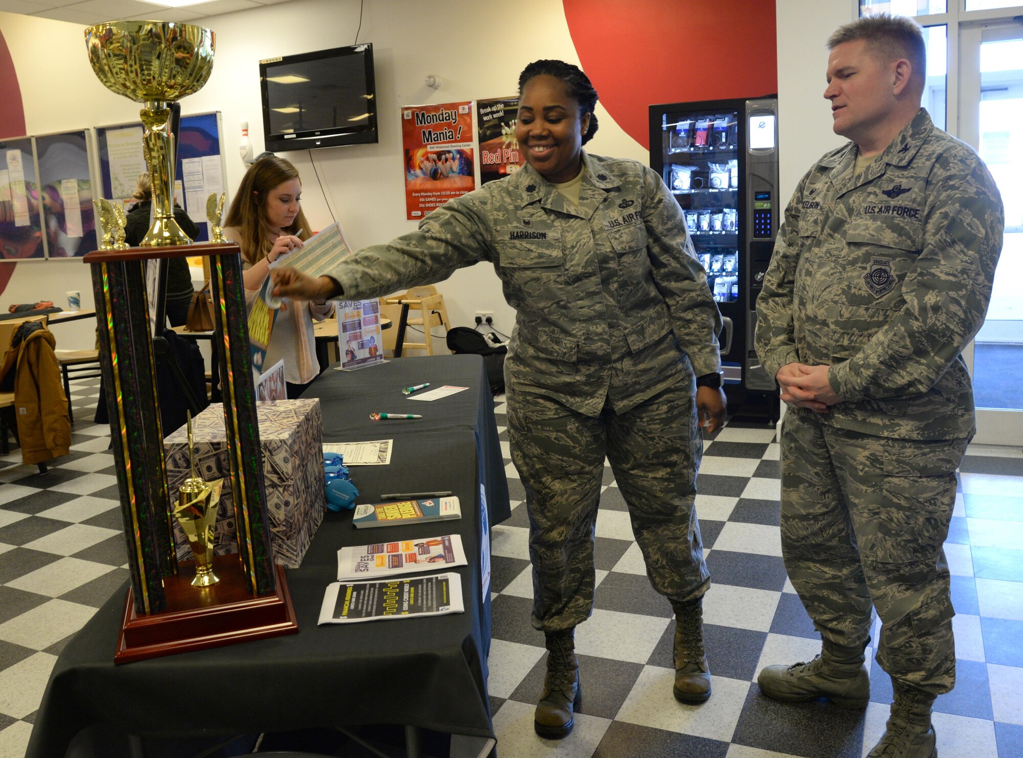 U.S. Air Force Col. Thomas Torkelson, 100th Air Refueling Wing commander, right, looks on as U.S Air Force Lt. Col. Carina Harrison, 100th Forces Support Squadron commander, makes a Saver Pledge, Feb. 13, 2017, at the bowling center on RAF Mildenhall, England. A Saver Pledge is a written and signed commitment for a member to be more financially conscious and to enroll as a Military Saver. (U.S. Air Force photo by Senior Airman Justine Rho)