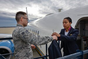 Senior Airman Joseph Shank, 89th Aerial Port Squadron fleet services agent, hands a suit coat to Staff Sgt. Porsha Cook, 1st Airlift Squadron flight attendant, prior to a C-40B mission to Europe, departing from Joint Base Andrews, Maryland, Feb. 3, 2017. FAs are known for their unprecedented professionalism and service, catering to America’s most important leaders and diplomats.