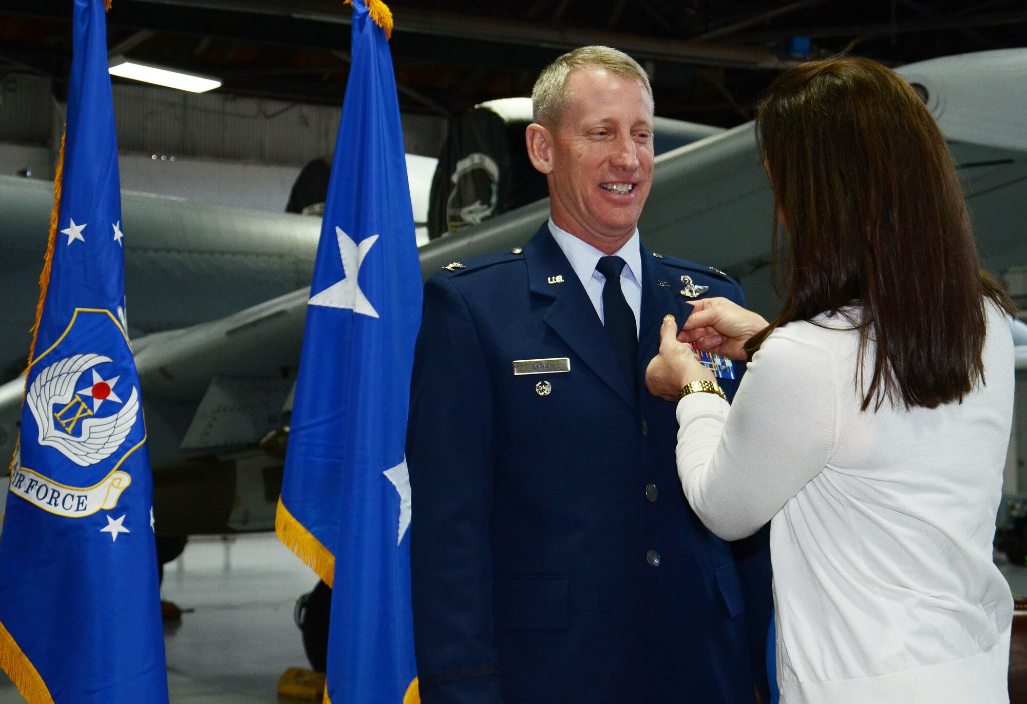 U.S. Air Force Col. Scott Caine, 9th Air Force vice commander, stands as his wife, Pam Caine, pushes in his retirement pin, Shaw Air Force Base, S.C., Feb. 10, 2017. Caine retired after 30 years in the Air Force and served in various positions throughout his career such as an aircraft maintenance officer, an A/OA-10 instructor, evaluator and pilot, and an operations officer. (U.S. Air Force photo by Tech. Sgt. Amanda Dick)