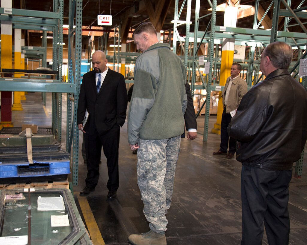 Christopher Camacho, Area Manager, DLA Disposition Services (left); and U.S. Air Force Lt. Gen. Andrew E. Busch, director, Defense Logistics Agency; look at damaged doors taken from High Mobility Multipurpose Wheeled Vehicles, aka Humvees, as Busch tours a DLA warehouse with Joseph Hayward, Supply Management Specialist, DLA Distribution and Brent Cox, Director, DLA Distribution aboard Marine Corps Logistics Base Barstow Jan. 26.