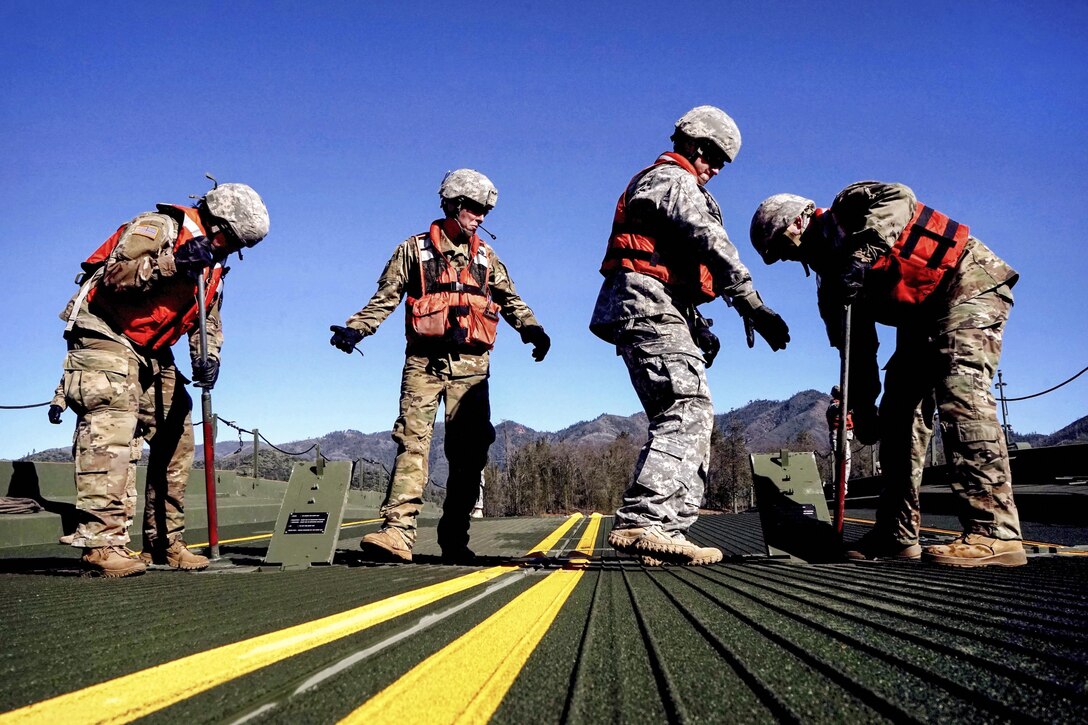 Army National Guard soldiers secure a ramp on a temporary floating bridge at Whiskeytown Lake near Redding, Calif., Feb. 11, 2017. The unit was practicing emplacing the improved ribbon bridge as part of its monthly training. Army National Guard photo by Spc. Amy E. Carle