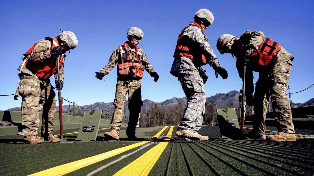 Army National Guard soldiers secure a ramp on a temporary floating bridge at Whiskeytown Lake near Redding, Calif., Feb. 11, 2017. The unit was practicing emplacing the improved ribbon bridge as part of its monthly training. Army National Guard photo by Spc. Amy E. Carle