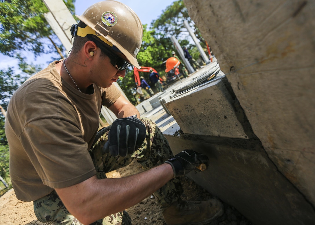 Navy Seaman Brandon Kase, a builder with Naval Mobile Construction Battalion 5, a Chicago native, spreads cement during the construction of a classroom at Ban Nong Mang School in Rayong, Thailand, during exercise Cobra Gold, Jan. 30, 2017. Marine Corps photo by Cpl. Wesley Timm